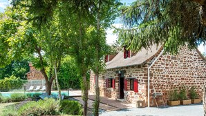 A stone building with a red door, a pool, and a garden area. - Beautiful Holiday Home With Pool in Teillots (Teillots)