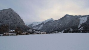 Un paysage montagneux enneigé, avec des bâtiments au premier plan.