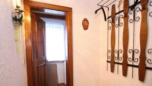 A hallway with a wooden door, a small refrigerator, and a wall-mounted rack with hooks. - Spacious Apartment near Ski Area in Salzburg (Dienten am Hochkoenig)