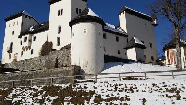 Ett slott med flera torn och en mur av sten.