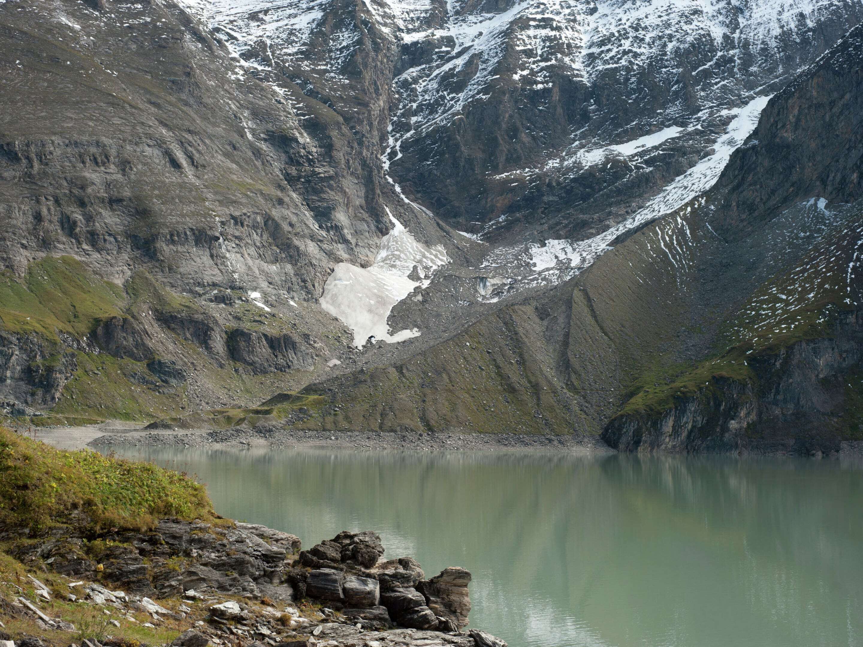 A mountainous landscape with a lake and a glacier.