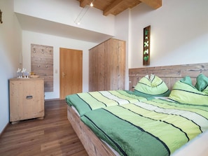 A bedroom with a wooden bed, a wardrobe, and a door.