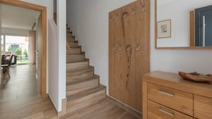 A staircase leading to a second floor, wooden wardrobe with hooks, and a wooden cabinet with drawers. - Chalet in Niedernsill Near Ski Slopes (Niedernsill)