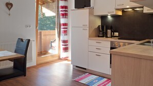A modern kitchen with a built-in TV, a coffee maker, and a stove. - Apartment in Zillertal Near Ski Slopes (Fuegenberg)