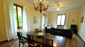 A dining area with a large table, chairs, a chandelier, and a patterned floor. - Hillside Villa in the Heart of Chianti (San Casciano in Val di Pesa)