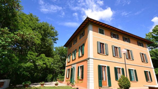 A two-story building with a flat roof, green shutters, and a garden in front. - Hillside Villa in the Heart of Chianti (San Casciano in Val di Pesa)