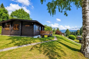 A log cabin with a deck, surrounded by lush greenery and a clear sky. - Spacious Chalet in Wörgl-boden near Ski Area (Woergl)