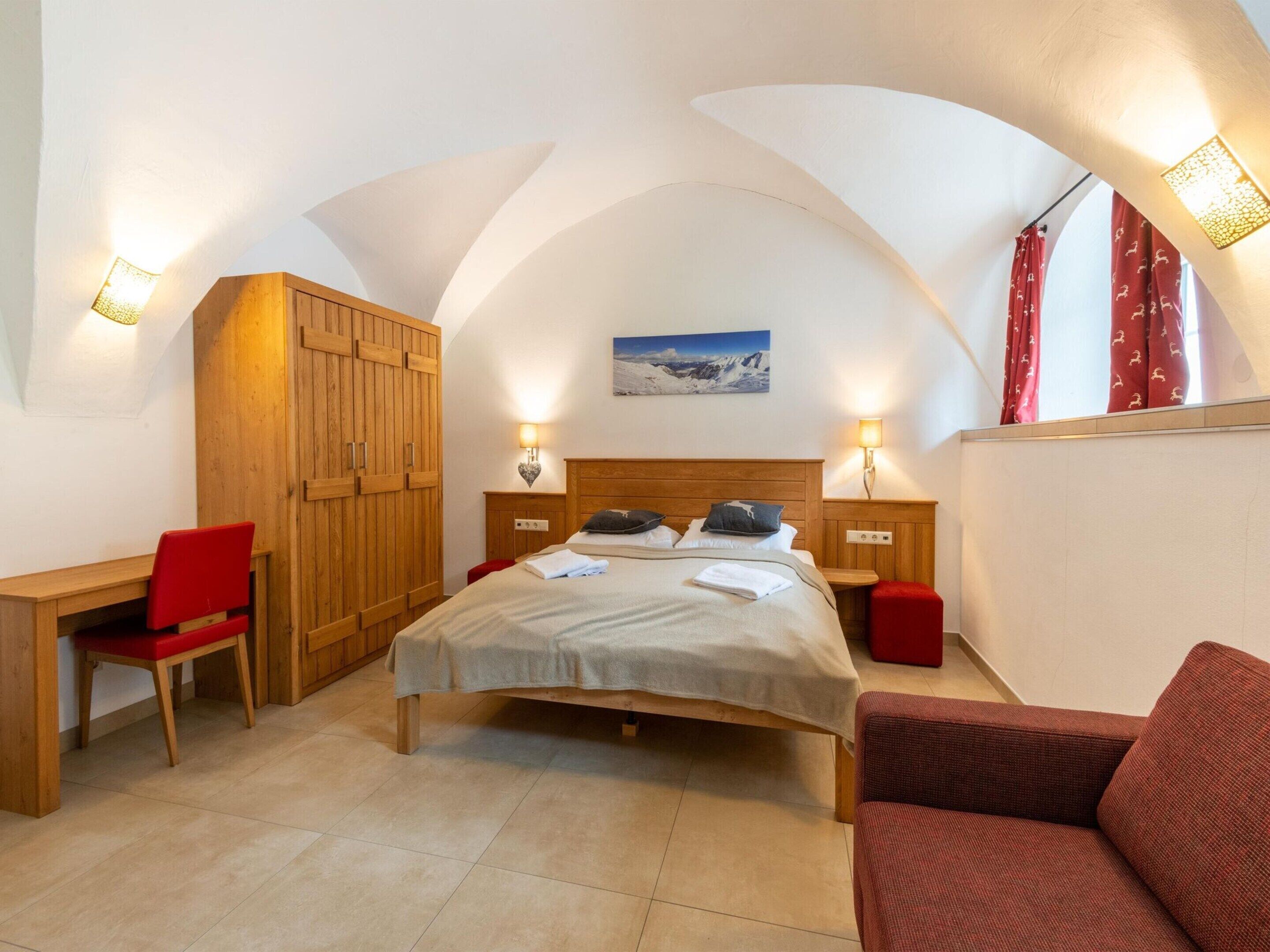 Une chambre à coucher comprenant un lit, un bureau, une chaise et une armoire.