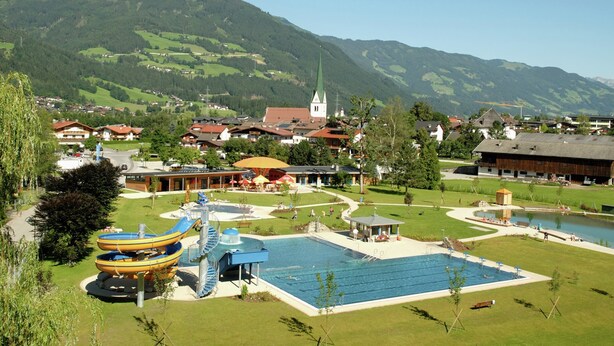 A resort with a swimming pool, water slides, and a view of mountains. - Apartment in Aschau Near Hochzillertal Slopes (Aschau Im Zillertal)