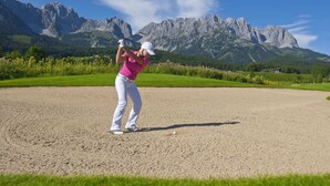 En golfbane med et bjergrigt baggrundsmotiv.
