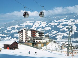 A hotel with multiple floors, ski lifts, and a snowy mountain backdrop. - Beautiful Apartment in Fugen / Zillertal (Fuegen)