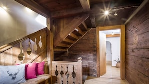 A wooden interior with a bench, a staircase, and a door leading to another room. - Farmhouse in Hopfgarten Near Ski Bus (Hopfgarten im Brixental)