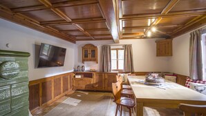 A wooden interior with a dining table, chairs, a television, and a cabinet. - Farmhouse in Hopfgarten Near Ski Bus (Hopfgarten im Brixental)