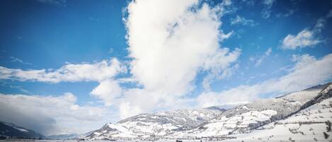Un paisaje nevado con cielo despejado y una montaña al fondo.