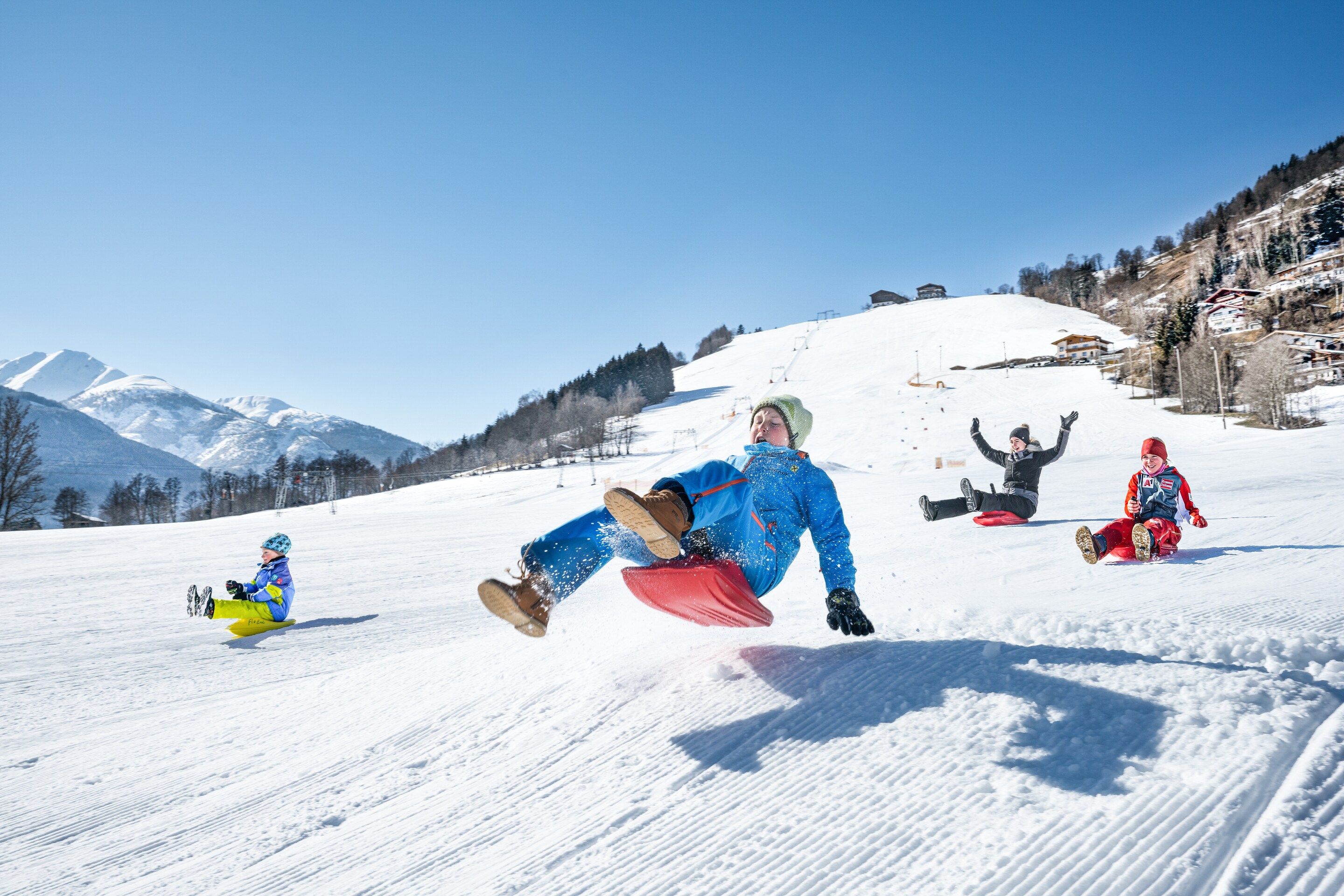 A snowy slope with skiers and snowboarders.