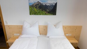 A double bed with white linens, two pillows, a wooden headboard, and a red throw blanket. - Luxurious Apartment in Fugenberg With Sauna (Fuegenberg)