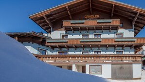A multi-story building with a prominent 'GANDOLER' sign, wooden balconies, and a snow-covered slope in the foreground. - Lovely Apartment in Mittersill near Kitzbühel - Kirchberg (Mittersill)