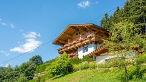 A traditional chalet with a sloped roof, wooden balconies with flower boxes, and surrounded by lush greenery. - Chalet in Wald Near Zillertal Ski Area (Wald im Pinzgau)