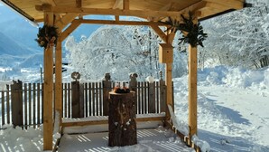 A wooden gazebo with a snow-covered roof, surrounded by a wooden fence and snow-laden trees. - Chalet in Wald Near Zillertal Ski Area (Wald im Pinzgau)