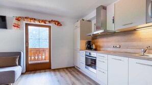 A compact kitchen with a built-in oven, a coffee maker, and a stainless steel range hood. - Chalet in Wald Near Zillertal Ski Area (Wald im Pinzgau)