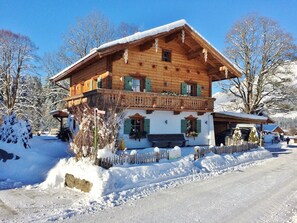 A wooden chalet with a balcony, snow-covered surroundings, and a clear sky. - Chalet in Ellmau Near Ski Slopes (Ellmau)