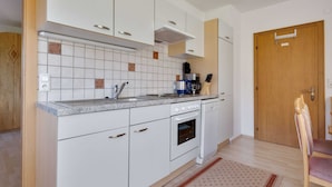 Eine moderne Küche mit weißen Schränken, einer Granit Arbeitsplatte und einem eingebauten Backofen.