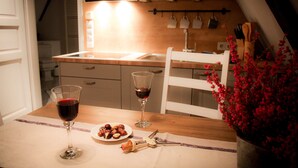 A kitchen with a wooden countertop, two wine glasses, a plate of food, and a bottle opener. - Altstadtzauber Lüneburg (Lueneburg)