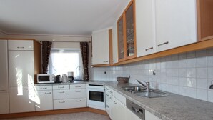 A kitchen with white cabinets, a microwave, a coffee maker, and a sink. - Spacious Chalet near Ski Area in Itter (Itter)