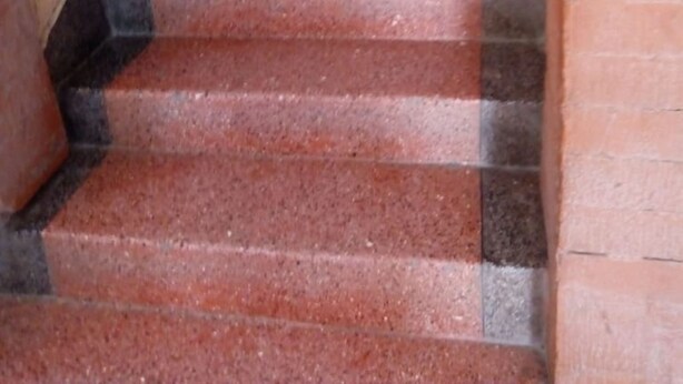 A staircase with red steps and black edges, leading upwards. - Jupiter House (Kitengela)