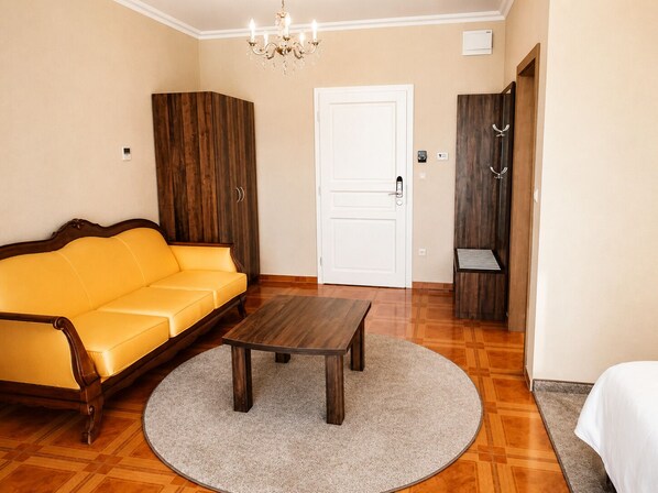 Una habitación con sofá, mesa, puerta y armario.