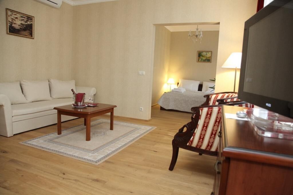 Una sala de estar con un sofá, una mesa de centro, un televisor y una silla.