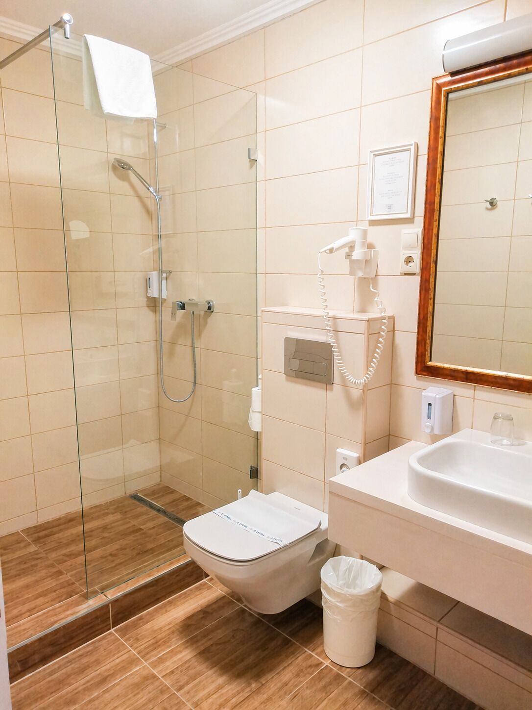 Un baño con ducha de vidrio, inodoro, lavabo y espejo.
