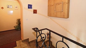 A hallway with a wooden ceiling, a black metal railing, and a wall with framed pictures and a decorative border. - Quaint Apartment in Finkenberg near Ski Lift (Finkenberg)
