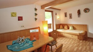 A cozy room with a wooden table, a bench, and a wall-mounted light fixture. - Quaint Apartment in Finkenberg near Ski Lift (Finkenberg)