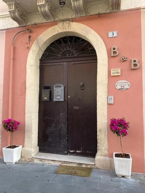 Una entrada con doble puerta y un letrero que indica 'Bed & Breakfast Phenixus'.