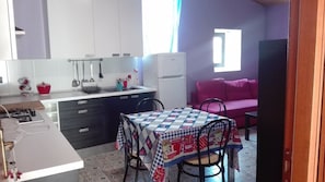 Una cocina compacta con una mesa de comedor, sillas y una zona de kitchenette.