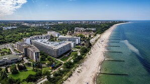An aerial view of a coastal city with a long beach, modern buildings, and a park area. - Apartamenty Sun & Snow Seaside Kołobrzeg (Kolobrzeg)