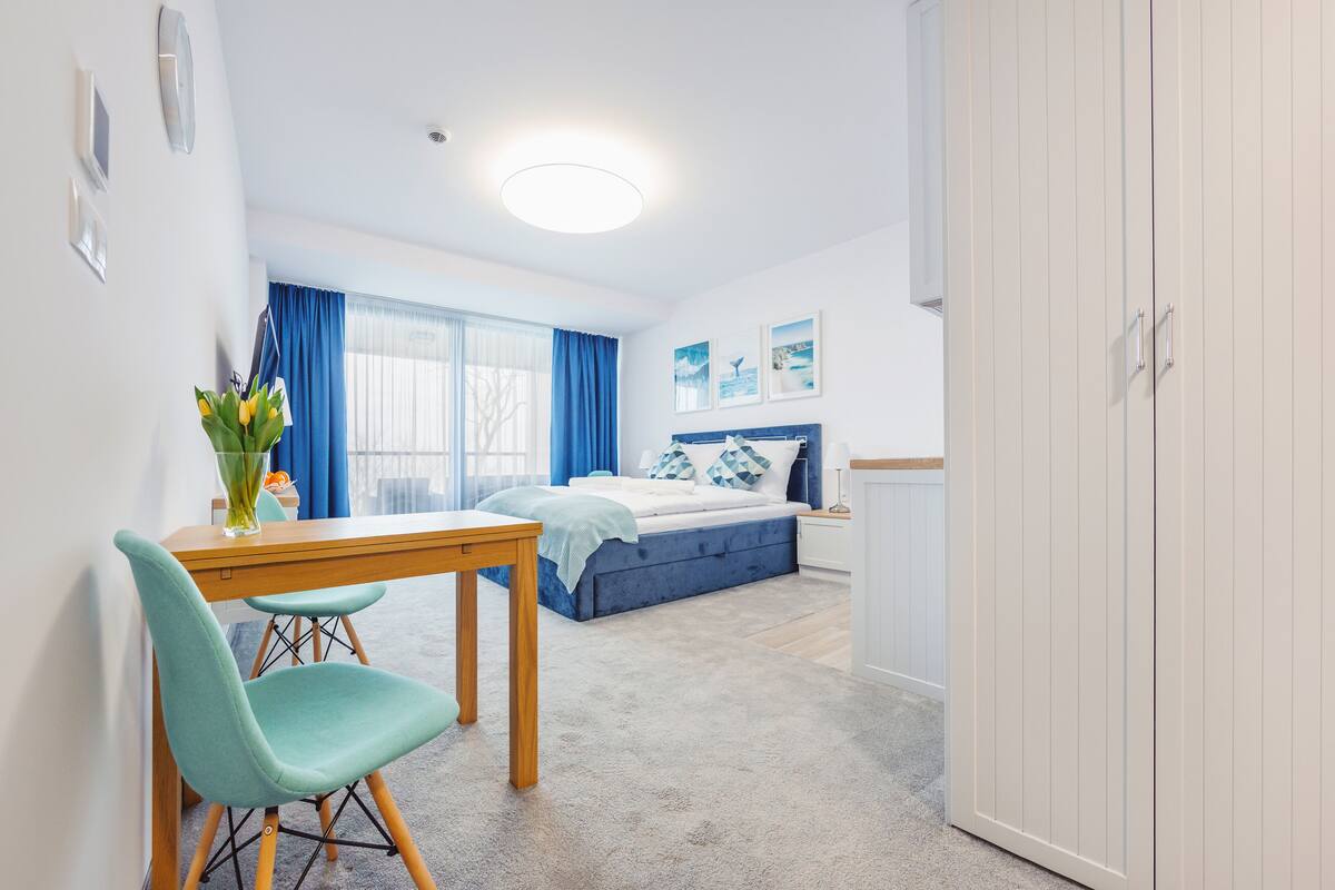 A modern bedroom with a bed, a desk, and a chair.