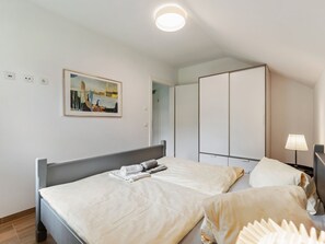 A bedroom with a bed, a wardrobe, a painting, and a lamp. - Apartment Sankt Michael Near Ski Lift (Sankt Michael im Lungau)
