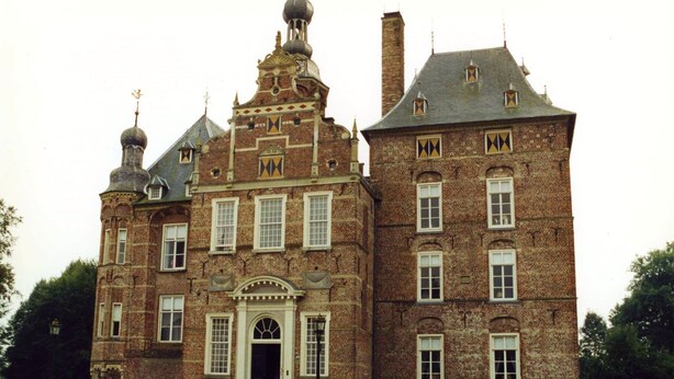 Ein großes, historisches Gebäude mit einer symmetrischen Fassade, zahlreichen Fenstern und einem zentralen Eingang mit einem dekorativen Bogen.