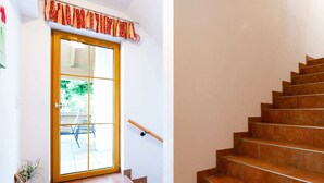 A staircase with brown tiles leading to a wooden door with a glass panel. - Apartment in Mittersill Near Kitzbuhel Ski Area (Mittersill)
