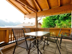 Enjoy a tranquil view of the surrounding landscape from this balcony with a table and four chairs.
