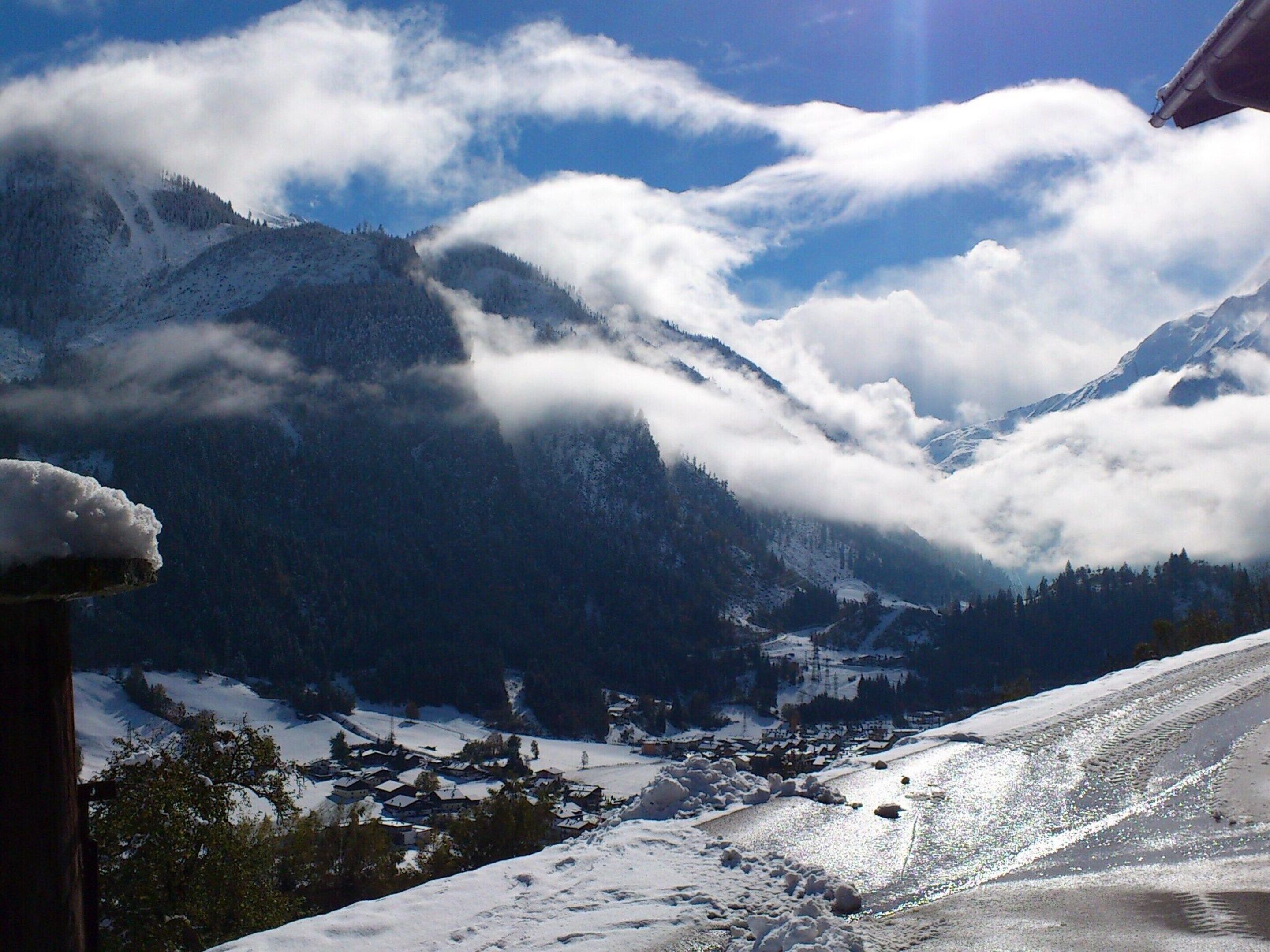 A snow-covered mountain landscape with a village in the valley.