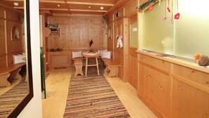 Un intérieur en bois avec un banc en bois, une table et une fenêtre décorée.