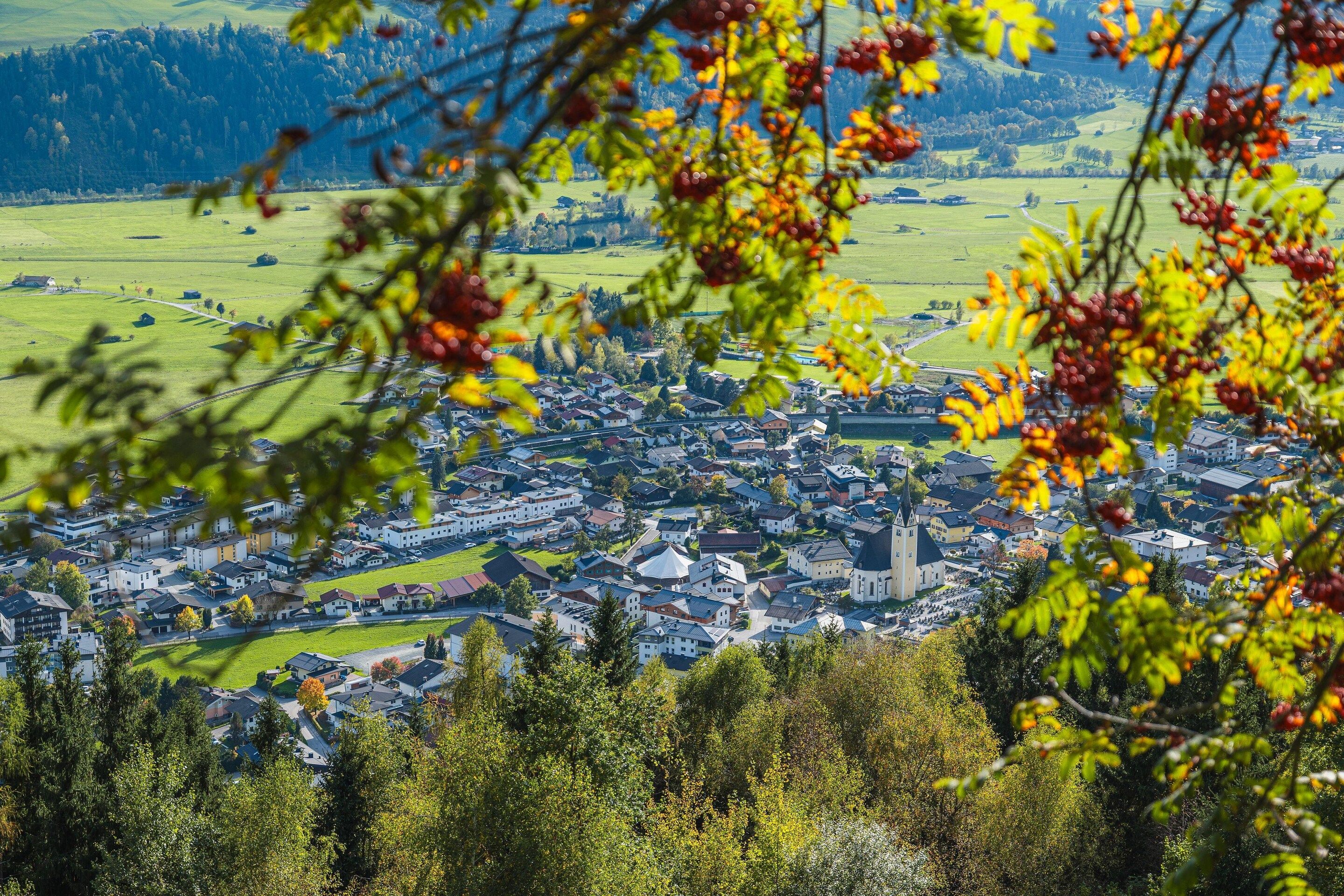 A town with a central church, surrounded by residential buildings and open fields.