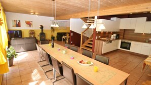 A spacious kitchen with a long island, wooden ceiling, and a dining area with chairs and a table. - Chalet in Furth Near Zell am See Ski Slopes (Piesendorf)