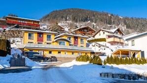 A snow-covered mountain village with colorful buildings, a paved road, and a clear blue sky. - Chalet in Furth Near Zell am See Ski Slopes (Piesendorf)