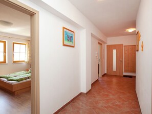 Un couloir avec un lit, une porte et un tableau accroché au mur.