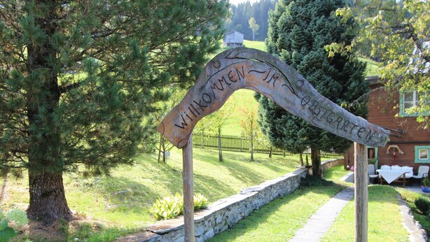A wooden archway with the inscription "Willkommen im Garten" in a garden setting. - Cozy Chalet in Bramberg am Wildkogel with Sauna near Ski Lift (Bramberg am Wildkogel)