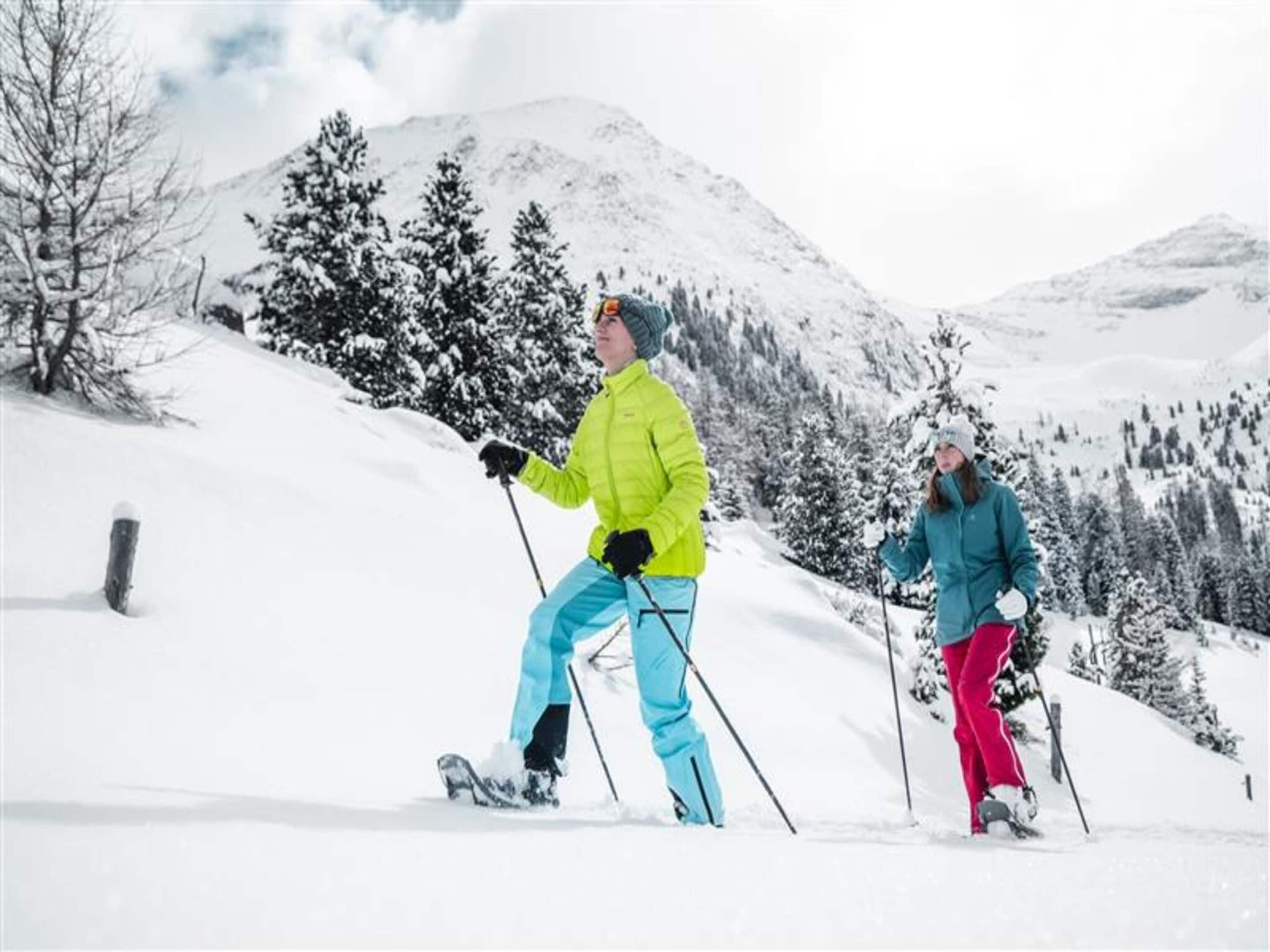 A snowy landscape with two people skiing.